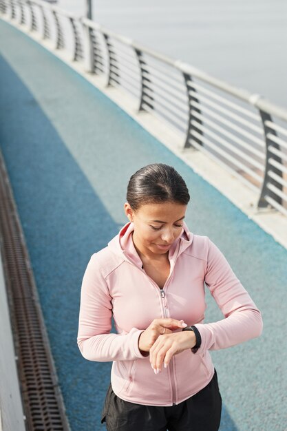 Vrouw die fitnessarmband gebruikt tijdens het hardlopen