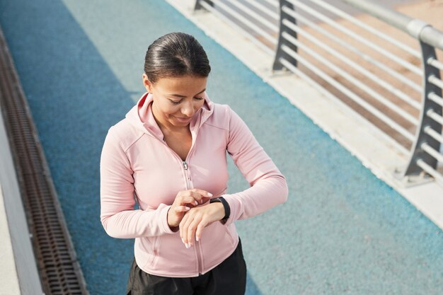 Vrouw die fitnessarmband gebruikt