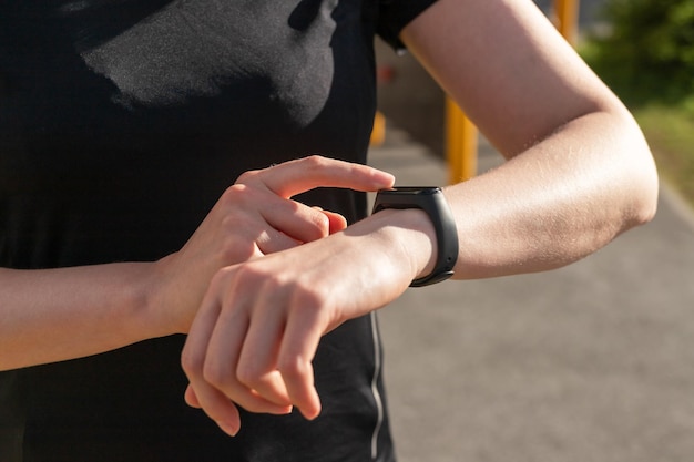 Vrouw die fitnesstracker gebruikt voor het lopen van stappen die afstand lopen of hartslagmonitoring Vrouwelijke handen close-up Verbetering van het fysieke welzijn