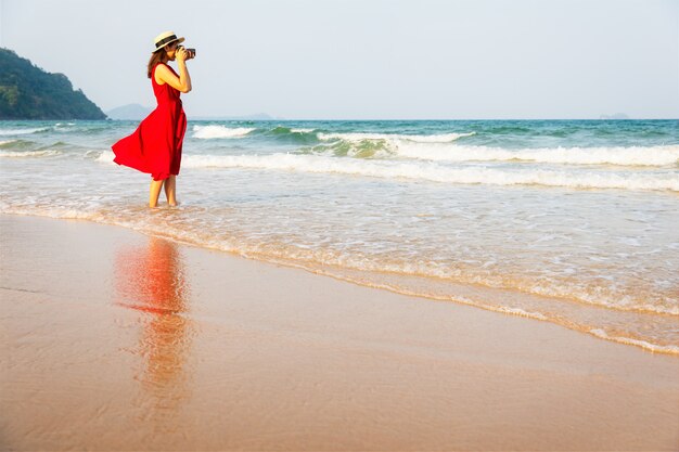 Vrouw die foto op strand neemt