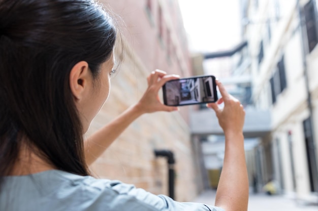 Vrouw die foto's maakt van de straat met haar mobiele telefoon