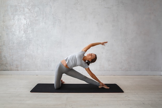 Vrouw die geavanceerde yoga uitoefenen.