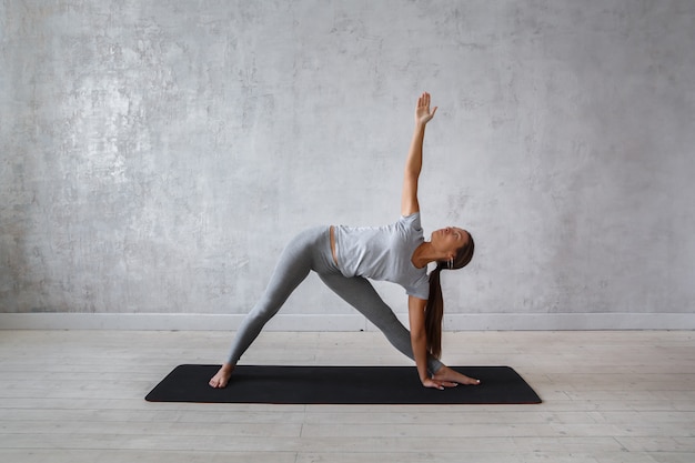 Vrouw die geavanceerde yoga uitoefenen.