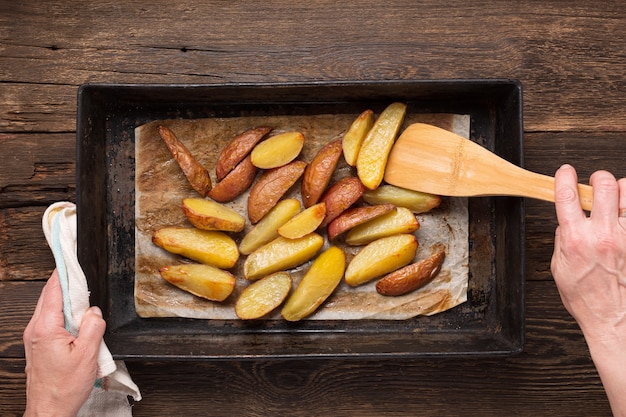 Vrouw die gebakken aardappelen serveert voor de lunch