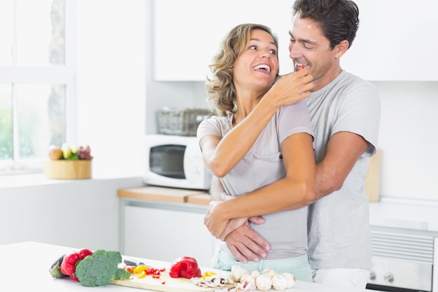 Vrouw die gekscherende man in keuken voedt