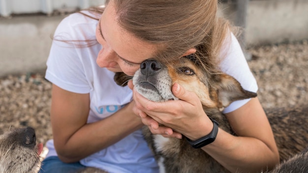 Foto vrouw die genegenheid toont om hond bij asiel te redden