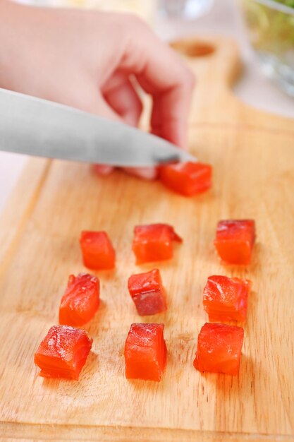 Vrouw die gerookte zalm snijdt voor salade in de keuken