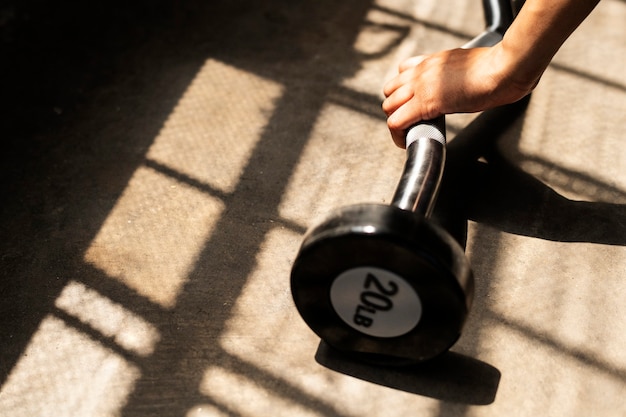 Vrouw die gewichtheffen met barbell uitoefent bij fitness gym