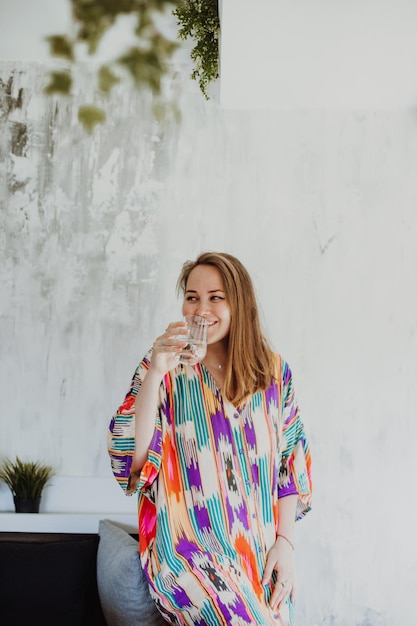 Vrouw die glas stilstaand water vasthoudt en drinkt om uitdroging te voorkomen