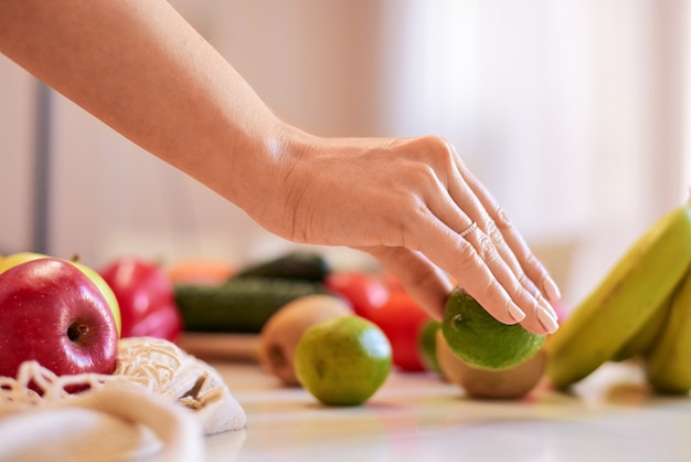 Vrouw die groene kalk met andere vruchten houdt