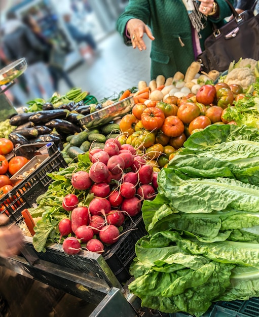 Vrouw die groenten op de markt kiest