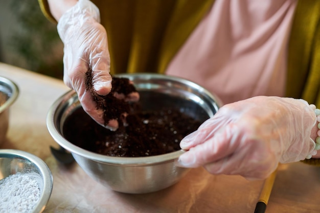 Vrouw die grond in pot bemest om te planten