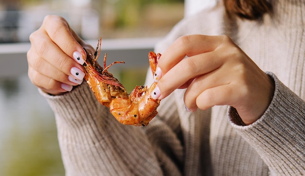 Vrouw die grote gebraden koningsgarnaal eet