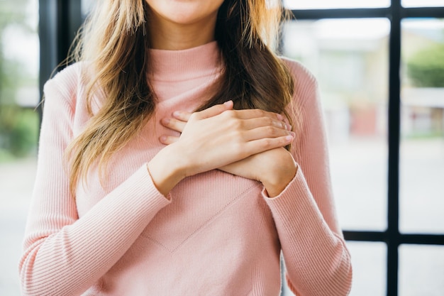 Vrouw die haar borst aanraakt om thuis te bedanken