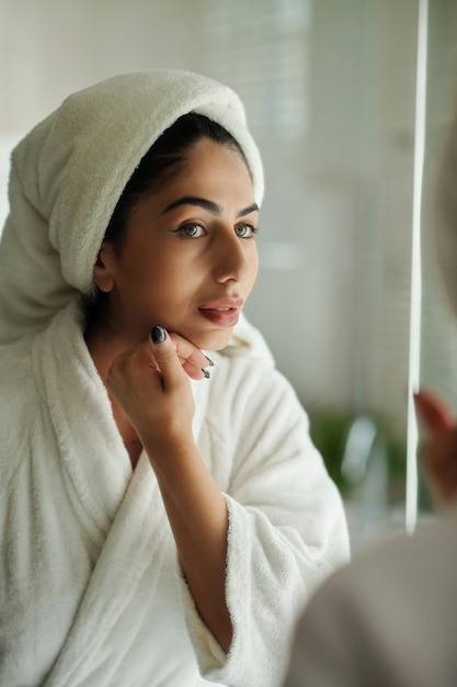 Vrouw die haar gladde huid aanraakt