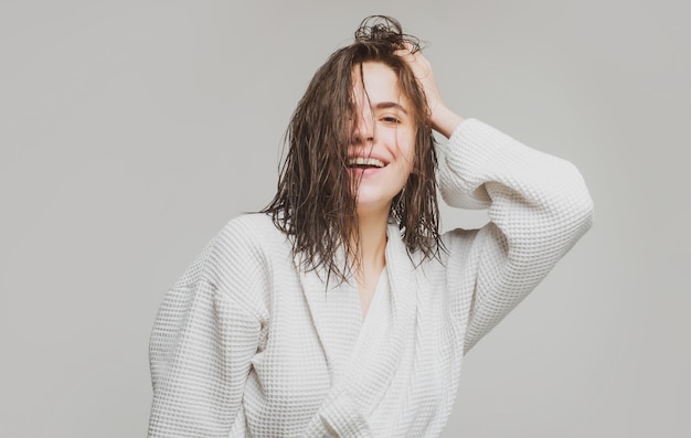 Vrouw die haar haar aanraakt Een mooi jong meisje in de studio met nat haar Schoonheid haarverzorging cosmetica