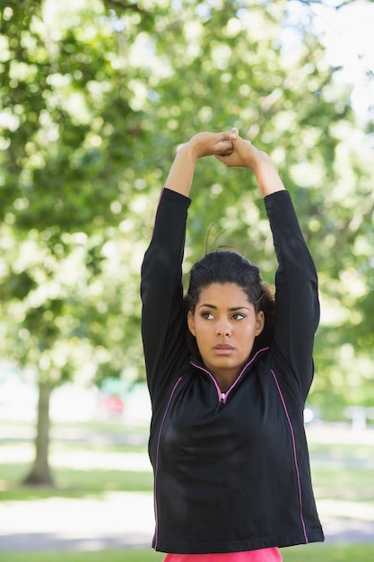 Vrouw die haar handen uitrekt tijdens oefening bij park