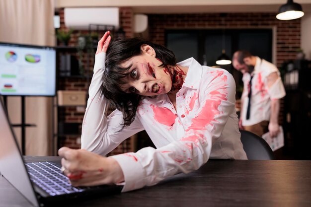 Vrouw die haar hoofd slaat van frustratie van te veel werk en eruit ziet als een zombie.