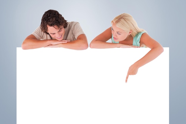 Foto vrouw die haar man iets laat zien op een whiteboard tegen grijs vignet