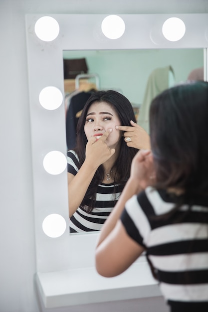 Vrouw die haar puistje drukt