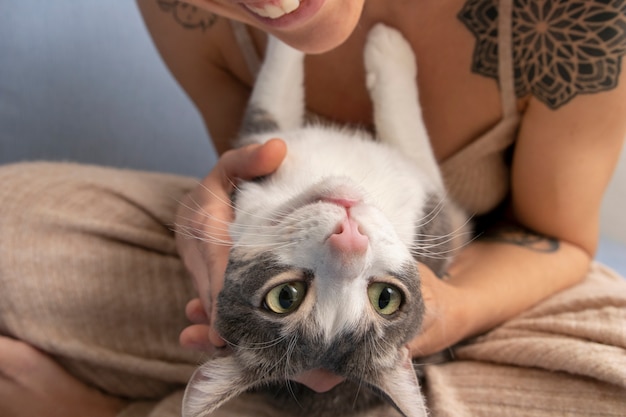 Foto vrouw die haar schattige kat binnen houdt