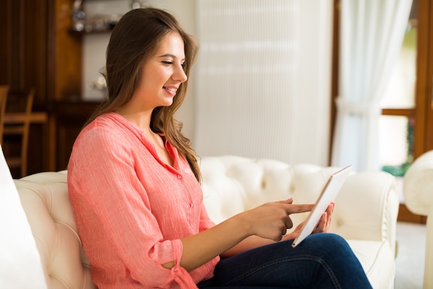 Vrouw die haar tablet thuis gebruikt