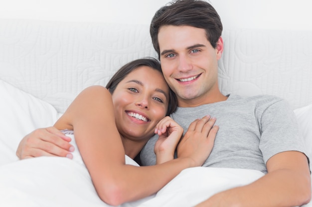 Vrouw die haar vriend in bed omhelst