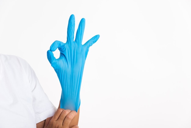 Vrouw die hand draagt en hand legt op blauwe rubberen latexhandschoen voor dokter met ok teken gebaren