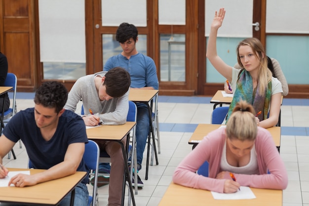 Vrouw die hand opheft tijdens examen