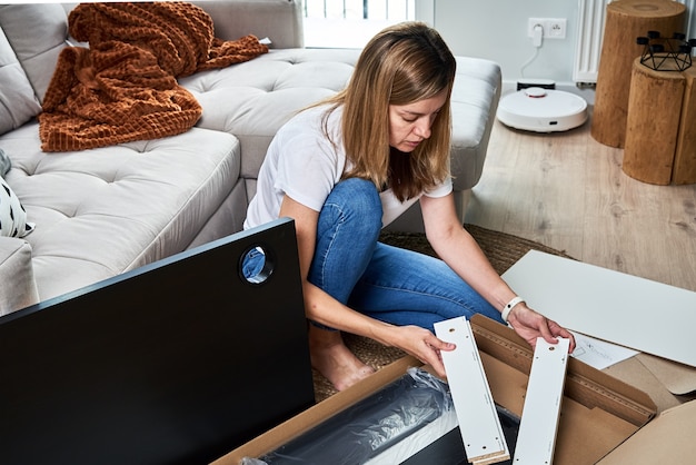 Vrouw die handleiding leest om meubels in elkaar te zetten