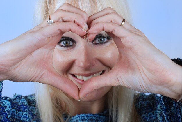 Foto vrouw die hartvorm maakt met haar handen