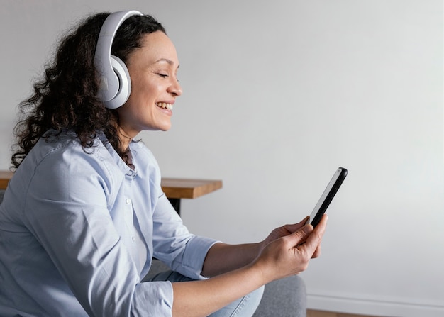 Vrouw die hoofdtelefoons middelgroot schot draagt