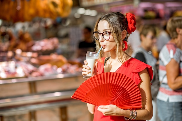 Vrouw die Horchata drinkt, traditionele Spaanse drank gemaakt van amandelen, staande in de centrale voedselmarkt van de stad Valencia