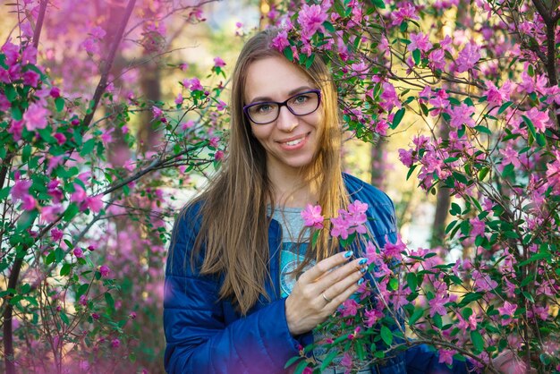 Vrouw die in de altai-bergen reist op de lente mooie bloeiende roze rododendron bloemen achtergrond