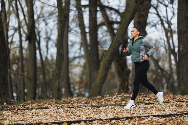 Foto vrouw die in de herfst door het bos loopt