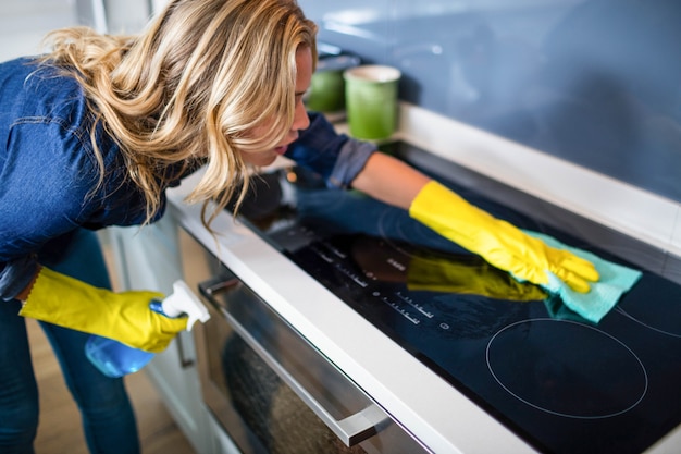 Vrouw die in de keuken schoonmaken