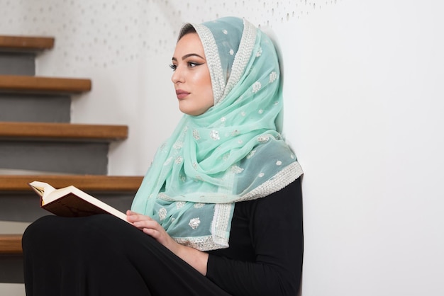 Vrouw die in de moskee bidt en de koran leest