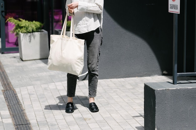 Vrouw die in de stad loopt met een witte eco-tas.