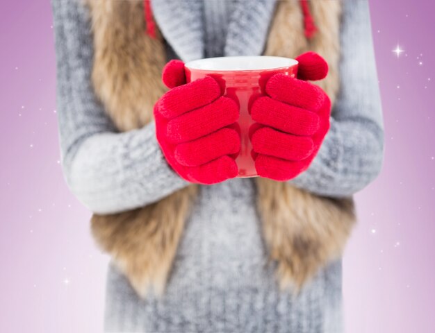 Vrouw die in de winterkleren een mok houdt