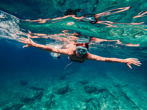 Vrouw die in het ondiepe zeewater snorkelt