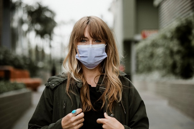 Vrouw die in het openbaar een gezichtsmasker draagt tijdens een pandemie van het coronavirus