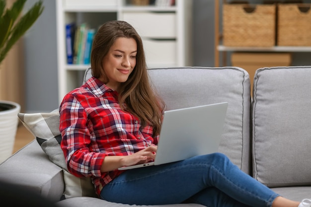 Vrouw die in laptop thuis werkt