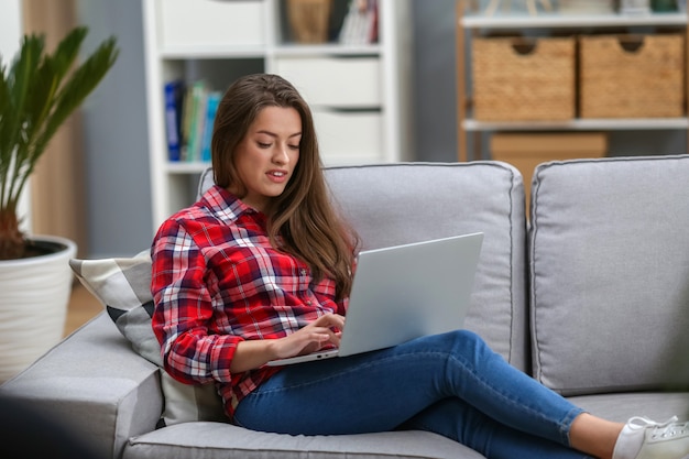 Vrouw die in laptop thuis werkt