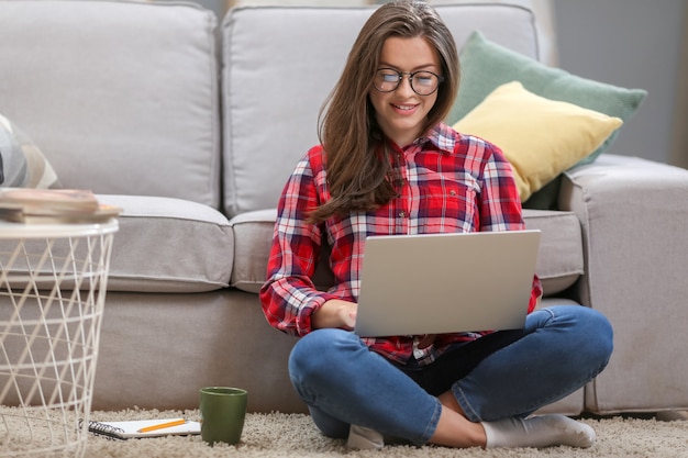 Vrouw die in laptop thuis werkt