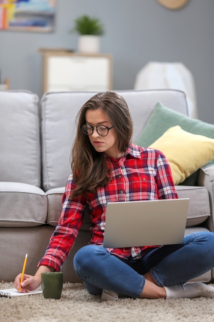 Vrouw die in laptop thuis werkt