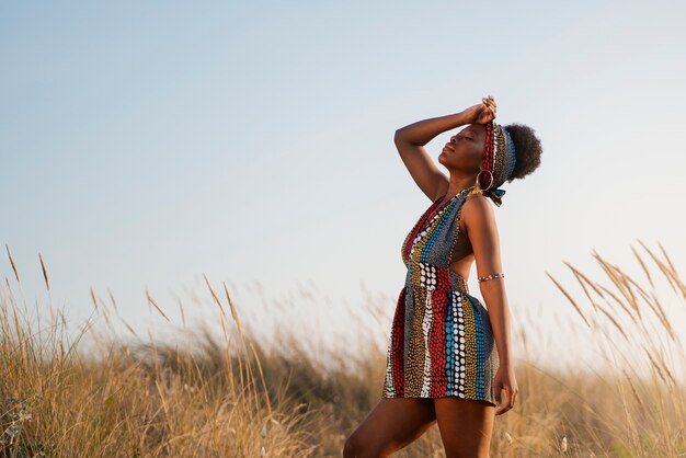 Vrouw die inheemse Afrikaanse kleding draagt in een dorre omgeving