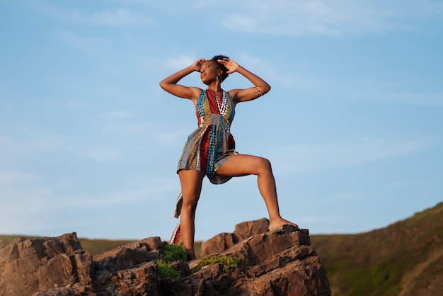 Vrouw die inheemse Afrikaanse kleding op berg draagt