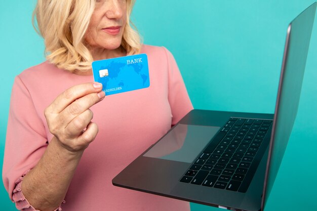 Vrouw die internet gebruikt om online te winkelen met computer en creditcard.