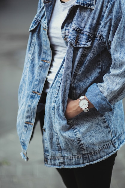 Vrouw die jeansjasje en horloge draagt