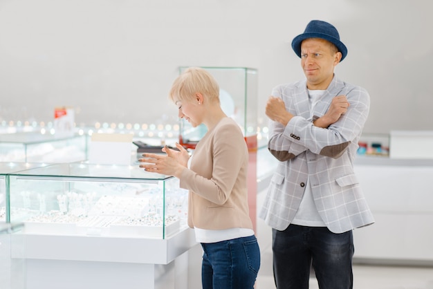 Vrouw die juwelen kiest, man in shock van de prijs